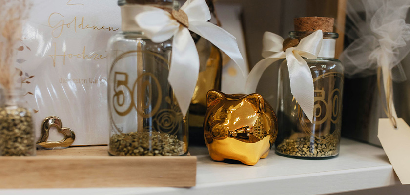 Goldenes Sparschwein steht neben verzierten Flaschen und festlicher Dekoration