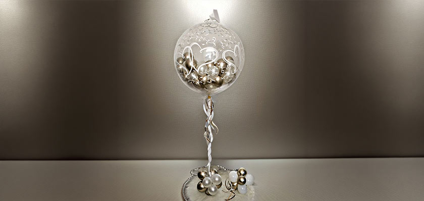 Elegante weiß-silberne Dekoration mit Glasornament und glänzenden Perlen